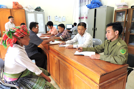 Cán bộ bộ phận một cửa xã Bản Công, huyện Trạm Tấu giúp người dân giải quyết TTHC. (Ảnh: Lộc Chầm)