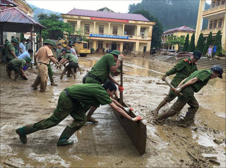 Tuổi trẻ Công an huyện Mù Cang Chải giúp nhân dân khắc phục hậu quả mưa lũ.