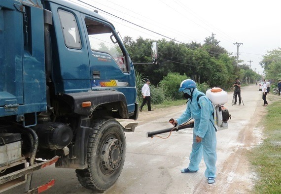 Lực lượng chức năng phun thuốc khử trùng phòng chống dịch bệnh trên đàn lợn ở Quảng Nam.