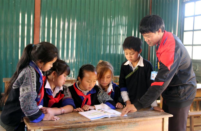 Giáo viên Trường Phổ thông DTBT Tiểu học và THCS Dế Xu Phình, huyện Mù Cang Chải hướng dẫn học sinh đọc sách, báo tại tủ sách nhà trường.