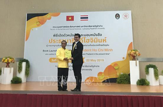 Hiệu trưởng Đại học Lampang Rajabhat, ông Somkiat Saithanoo, tặng sách cho đại diện Bộ Ngoại giao Thái Lan.

