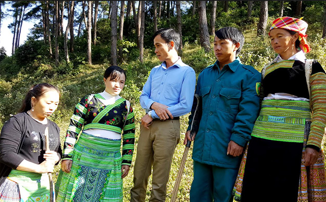 Ông Lại Văn Quang - Phó Giám đốc Ban Quản lý Rừng phòng hộ huyện Trạm Tấu (đứng giữa) tuyên truyền, hướng dẫn nhân dân chăm sóc, bảo vệ, phòng chống cháy rừng.