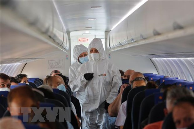 Tiếp viên hàng không mặc quần áo bảo hộ phòng lây nhiễm COVID-19 trên máy bay.