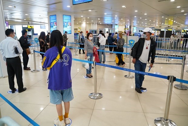 Hành khách tuân thủ khoảng cách tối thiểu khi làm thủ tục tại sân bay Nội Bài sau khi nới lỏng giãn cách xã hội.