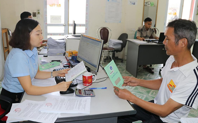 Cán bộ Bảo hiểm xã hội tỉnh Yên Bái bàn giao sổ bảo hiểm xã hội cho người lao động.