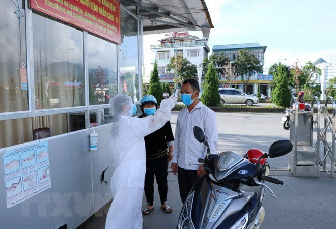 Cán bộ nhân viên y tế của Bệnh viện Đa khoa tỉnh Lai Châu kiểm soát đo thân nhiệt cho người dân trước khi vào khám bệnh.