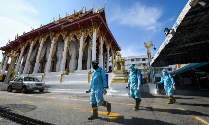 Nhân viên mặc đồ bảo hộ phun khử khuẩn tại khu Klong Toey, Bangkok, Thái Lan, hôm 16/5.