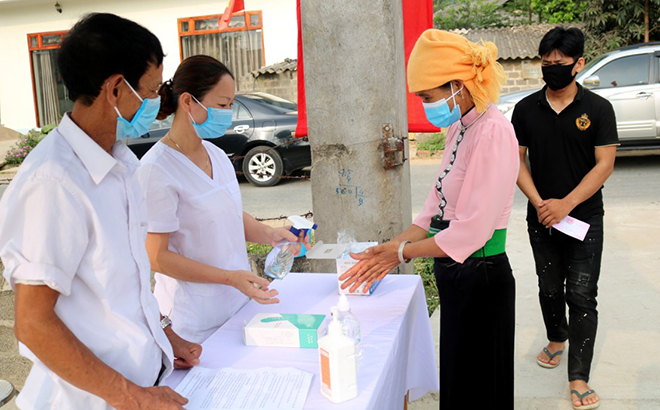 Cử tri thị xã Nghĩa Lộ thực hiện các biện pháp y tế trước khi vào bỏ phiếu bầu cử.