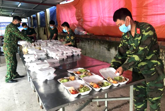 Officers and soldiers prepare meals for people staying in quarantine.
