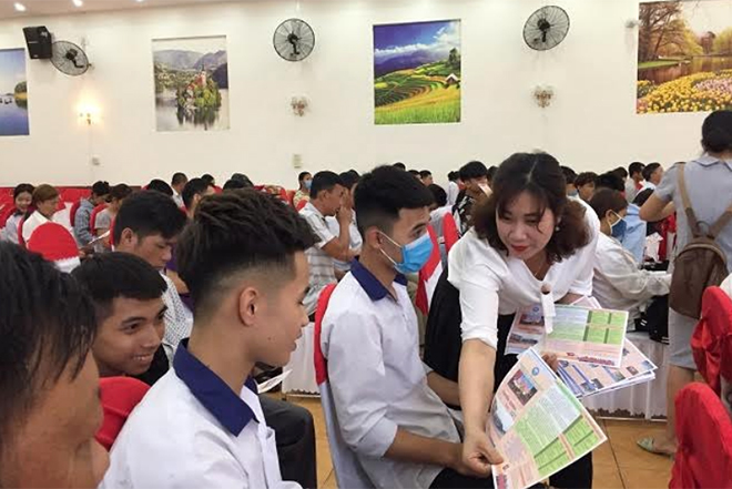 Các doanh nghiệp phát tờ rơi tư vấn các ngành nghề trong tương lai cho học sinh Trung tâm GDNN - GDTX huyện Trấn Yên trong ngày hội Tư vấn hướng nghiệp năm 2021. (Ảnh: Kim Oanh)