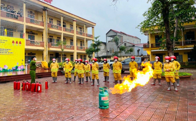 Cán bộ Phòng Cảnh sát phòng cháy, chữa cháy và cứu nạn, cứu hộ, Công an tỉnh hướng dẫn đội phòng cháy, chữa cháy Trường THPT Chu Văn An, huyện Văn Yên sử dụng các trang thiết bị phòng cháy. 
(Ảnh: Văn Cường)