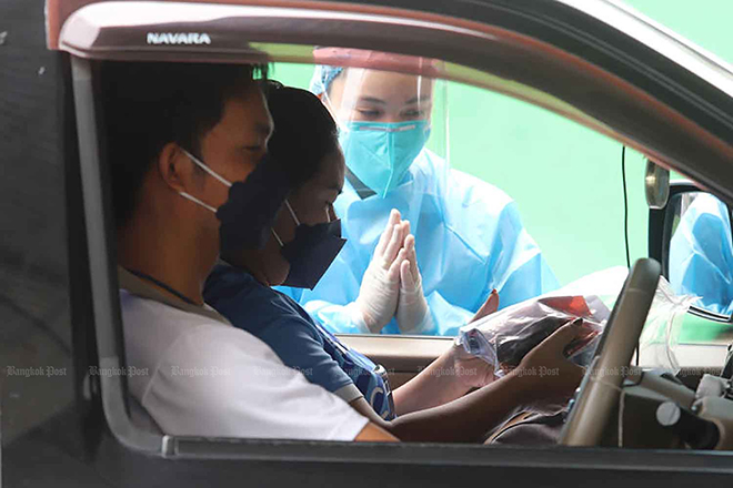 Những người bị nhiễm Covid-19 với các triệu chứng nhẹ lái xe đến và nhận thuốc điều trị Covid-19 tại Pathum Thani, Thái Lan.
