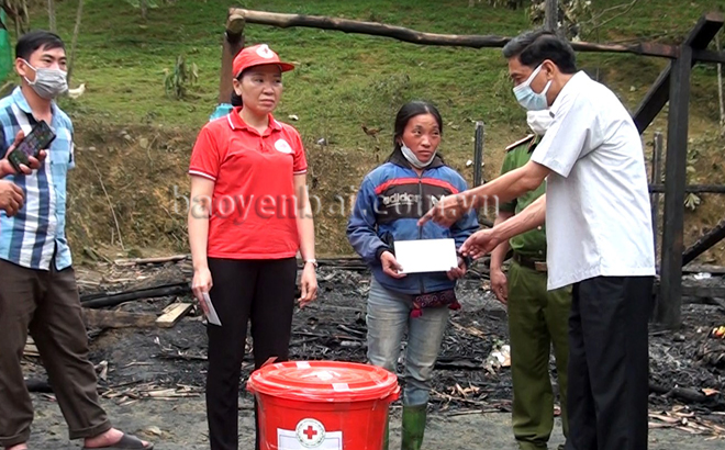Đồng chí Doãn Văn Thủy - Phó chủ tịch UBND huyện Văn Yên trao hỗ trợ 20 triệu đồng cho gia đình chị Giàng Thị Chứ.