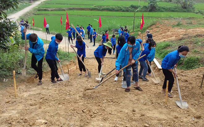 Đoàn viên thanh niên xã Lang Thíp, huyện Văn Yên san gạt mặt bằng để bê tông hóa đường nông thôn tại thôn Bùn Dạo.