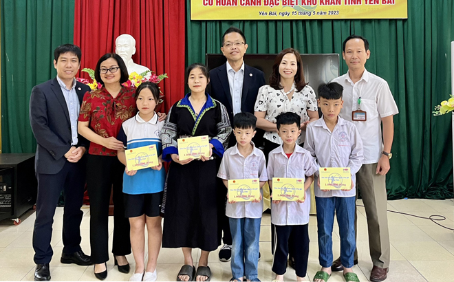 Representatives of the National Fund for Vietnamese Children and the Acecook Vietnam joint Stock Company present scholarships to students at Yen Bai Centre for Social Work and Social Protection)