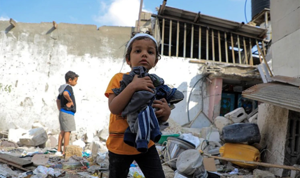 Các em nhỏ thu nhặt đồ đạc sót lại trong đống đổ nát của ngôi nhà bị phá hủy sau cuộc tấn công của Israel vào thành phố Rafah, Dải Gaza ngày 1/5/2024.