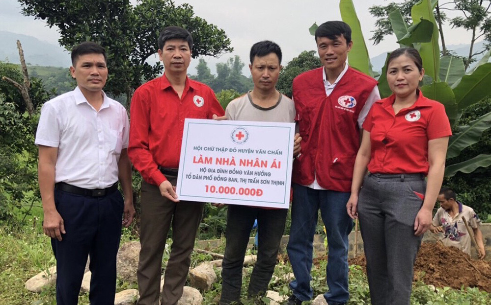 Hội Chữ thập đỏ huyện Văn Chấn trao tiền hỗ trợ cho hộ nghèo làm nhà ở.