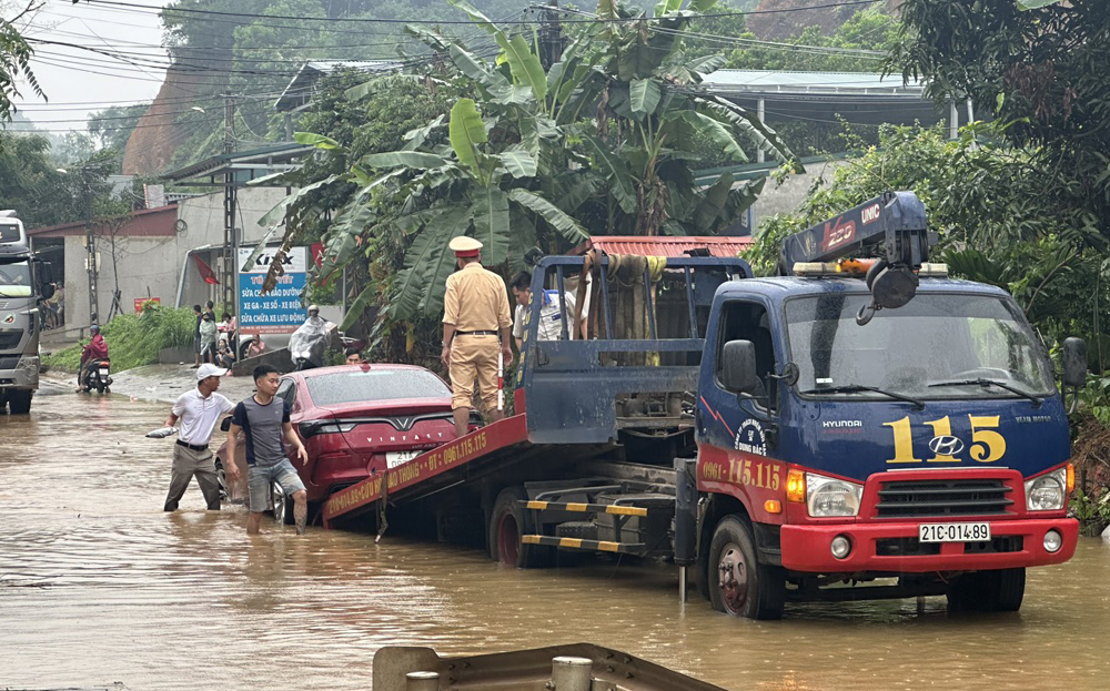 Lực lượng Cảnh sát giao thông Yên Bái hỗ trợ  một ô tô bị chết máy khi đi qua đoạn ngập nước