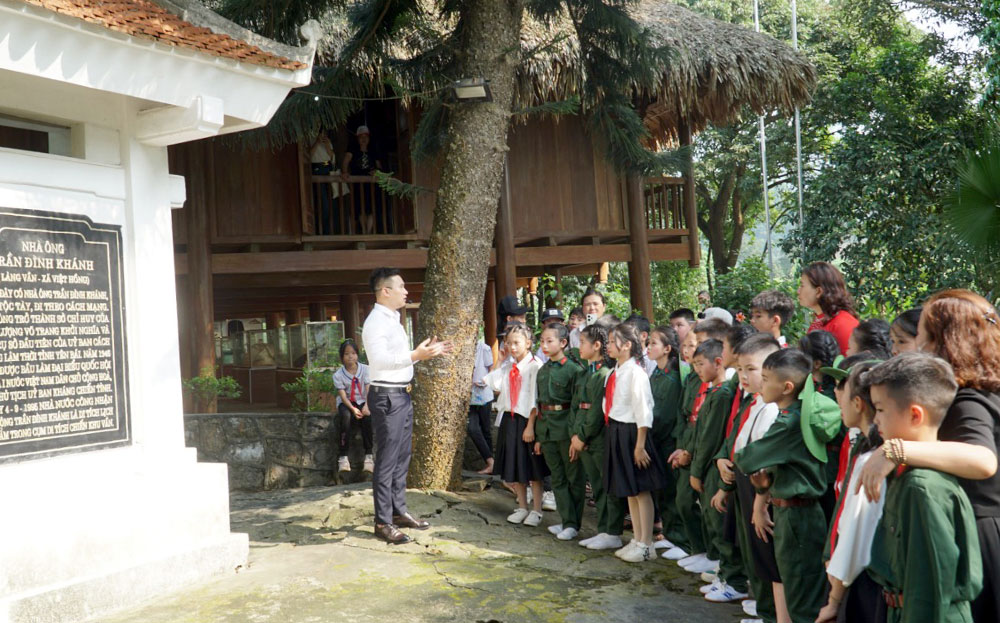 Các em học sinh thăm Di tích nhà ông Trần Đình Khánh tại làng Vần, xã Việt Hồng, huyện Trấn Yên.
