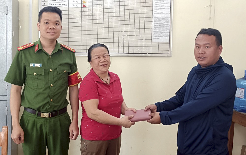 Anh Mùa A Lồng trả lại chiếc ví đã nhặt được cho chị Hoàng Thị Hải Yến ngay tại trụ sở Công an huyện Trạm Tấu