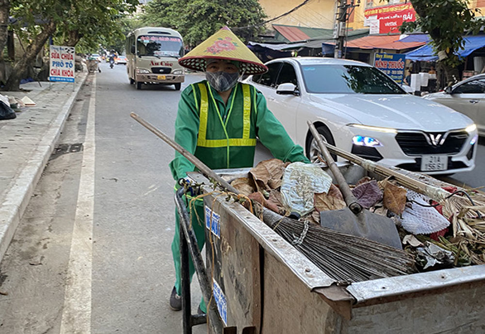 Công nhân Công ty cổ phần Môi Trường và Năng lượng Nam Thành thu gom rác thải tại khu vực chợ ga Yên Bái.