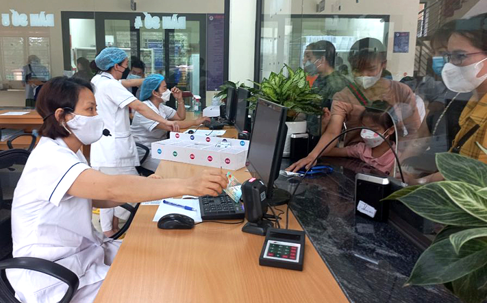 Viên chức BHXH huyện Trấn Yên tuyên truyền, vận động người dân tham gia BHYT hộ gia đình.