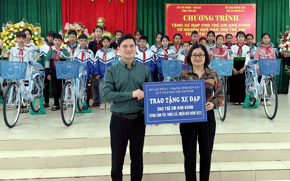 Đồng chí Nguyễn Thị Thu Hà - Phó Giám đốc Sở Lao động - Thương binh và Xã hội trao tặng xe đạp cho trẻ em có hoàn cảnh khó khăn ở thị xã Nghĩa Lộ từ nguồn Quỹ Bảo trợ trẻ em tỉnh.