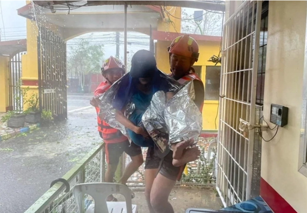 Lực lượng cứu hộ sơ tán một phụ nữ khỏi căn nhà bị ngập tại tỉnh Quezon do ảnh hưởng bão Ewiniar