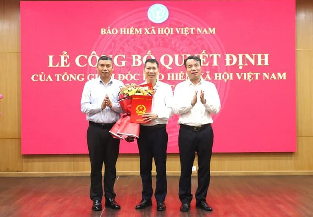 Tổng giám đốc BHXH Việt Nam Nguyễn Thế Mạnh (bên phải) và Phó chủ tịch UBND TP.Đà Nẵng Hồ Kỳ Minh (bên trái) chúc mừng ông Nguyễn Trí Đại