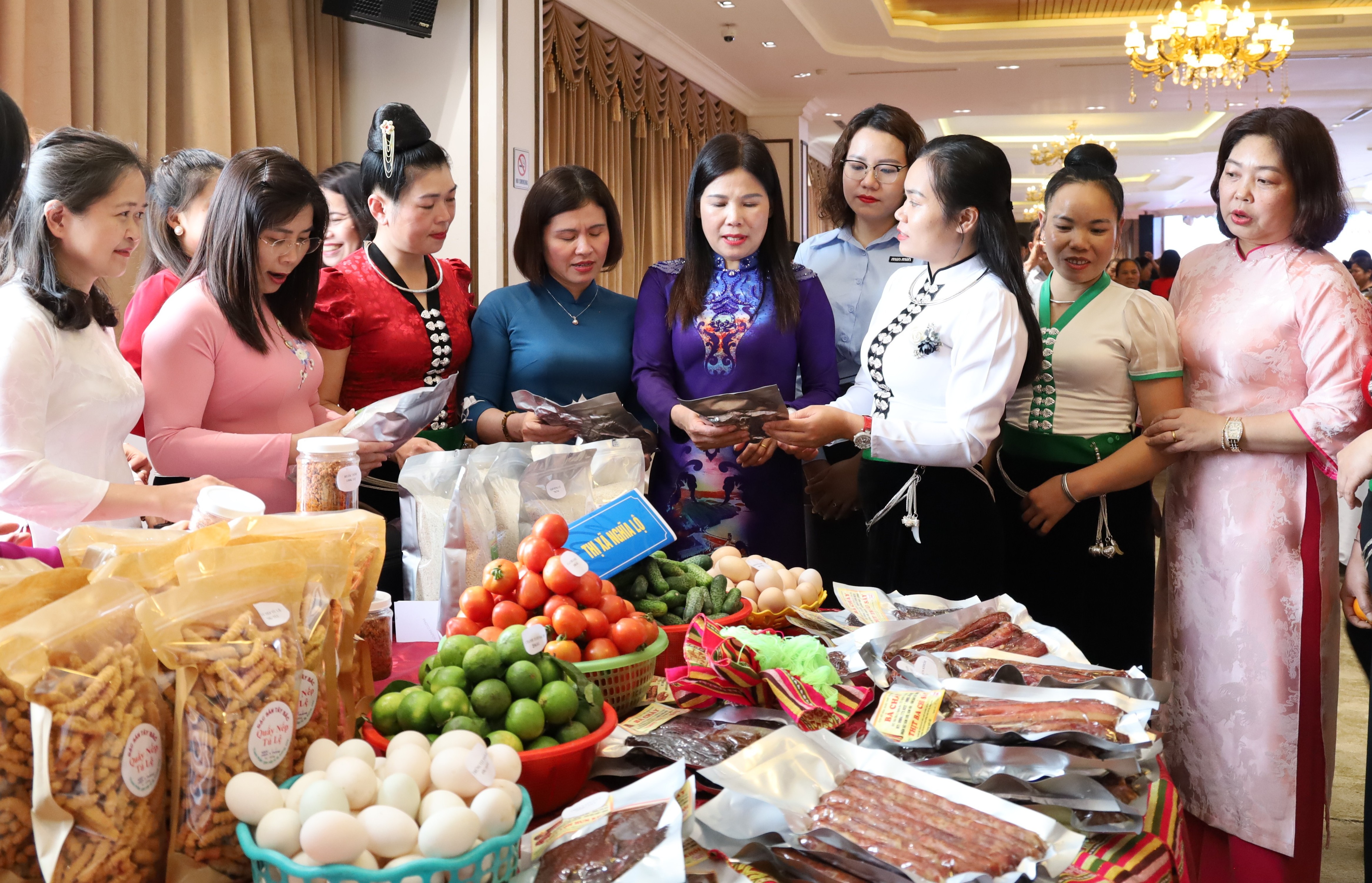 Chủ tịch Hội LHPN tỉnh Nguyễn Thị Bích Nhiệm (đứng giữa) trao đổi với chị em phụ nữ về quảng bá, giới thiệu sản phẩm nông sản do chị em làm ra.