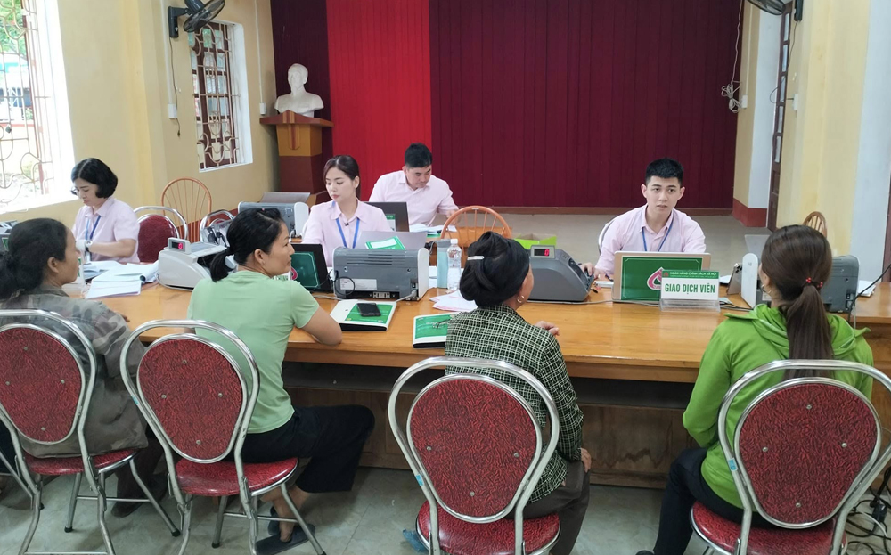 Cán bộ Phòng Giao dịch Ngân hàng Chính sách xã hội huyện Văn Yên làm thủ tục giải ngân vốn tín dụng cho vay hộ nghèo xã Lang Thíp.