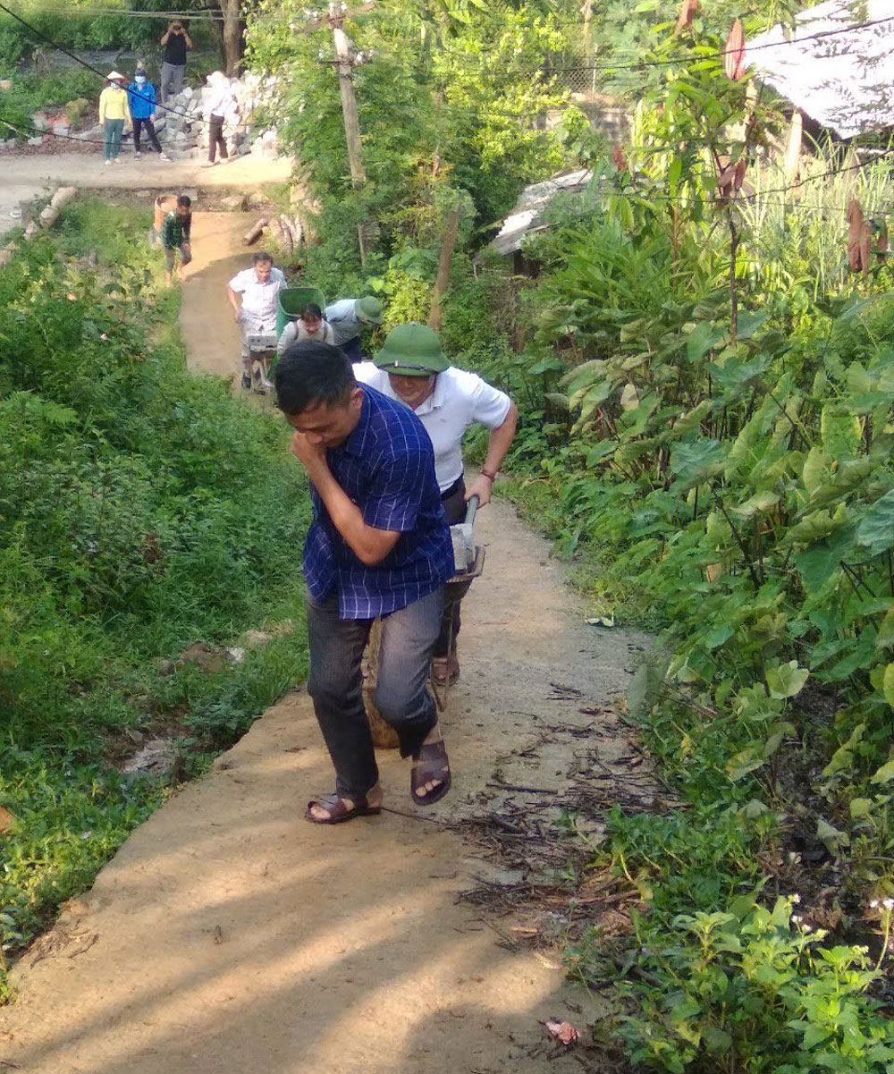 Lãnh đạo xã Hồng Ca cùng nhân dân chuyển vật liệu làm nhà cho hộ nghèo tại thôn Khe Ron.