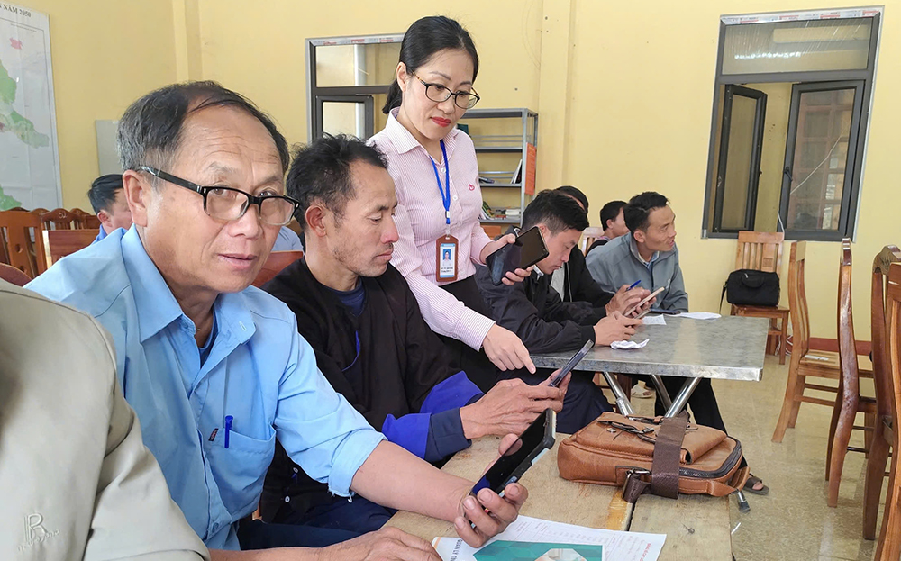 Cán bộ NHCSXH tỉnh hướng dẫn các tổ trưởng tổ TK&VV sử dụng ứng dụng quản lý TDCS.