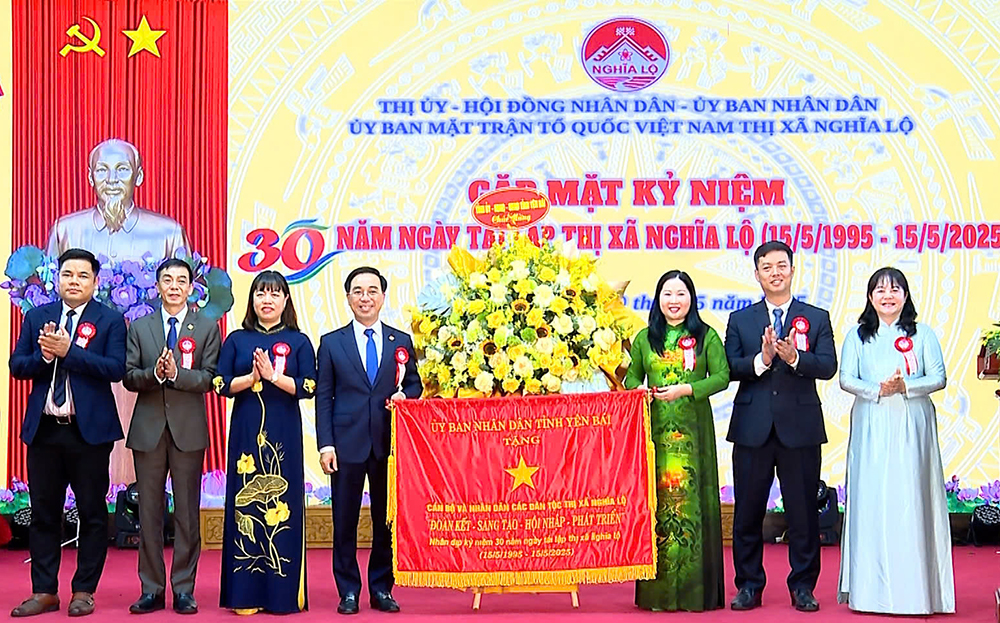 Các đồng chí lãnh đạo tỉnh tặng cờ và hoa chúc mừng Đảng bộ, nhân dân thị xã Nghĩa Lộ.