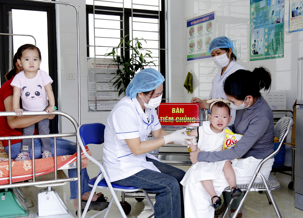 Cán bộ Trạm Y tế xã Nghĩa Tâm tiêm chủng cho trẻ em.