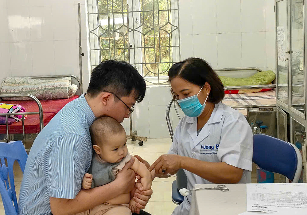 Cán bộ Trung tâm Y tế thành phố Yên Bái tiêm phòng sởi cho trẻ em.