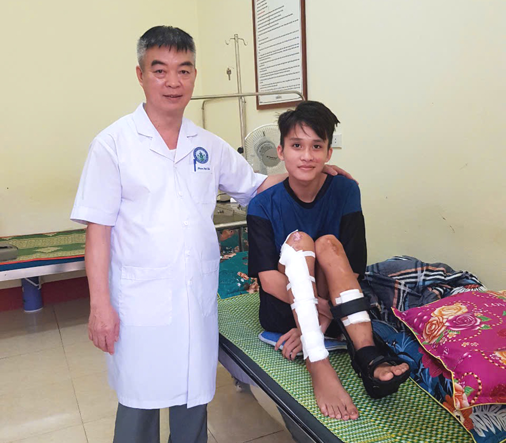 Bác sĩ Chuyên khoa II Phạm Anh Tiến - Trưởng khoa Ngoại tổng hợp, Trung tâm Y tế huyện Văn Chấn thăm, khám cho bệnh nhân.