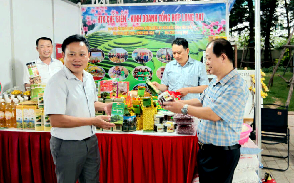Lãnh đạo Liên minh HTX tỉnh Yên Bái và đơn vị thành viên giới thiệu các sản phẩm OCOP và đặc sản vùng, miền Yên Bái với khách hàng tại Hội chợ