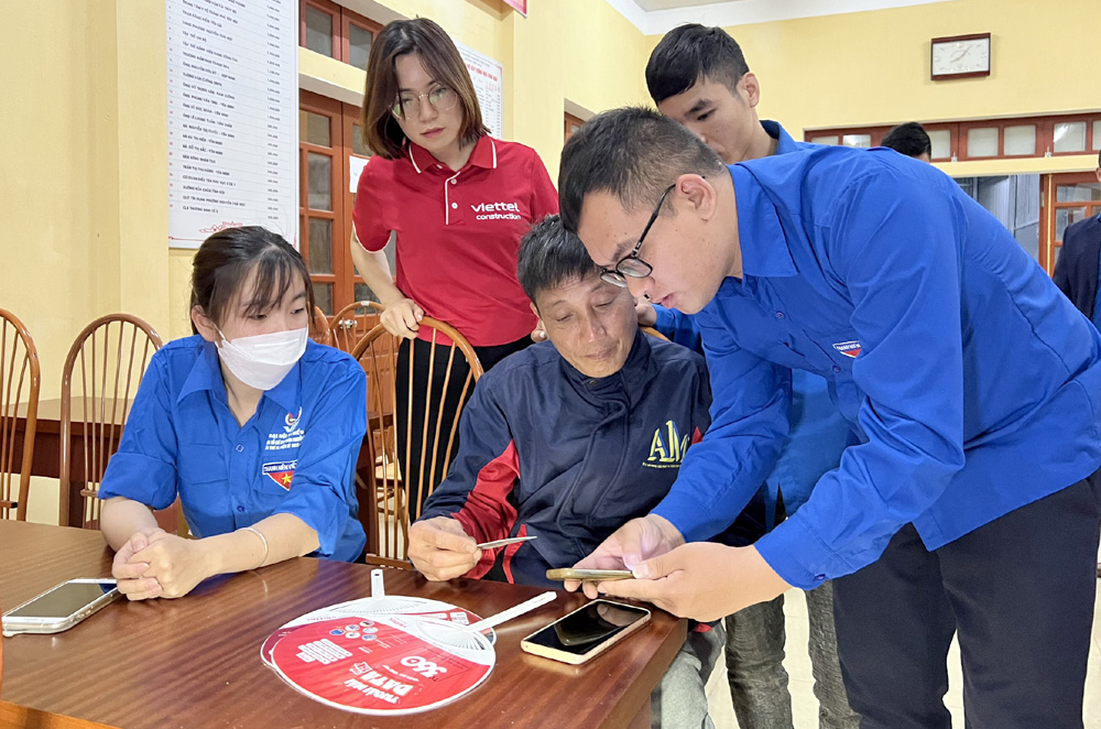 Thanh niên Yên Bái hỗ trợ người dân cài đặt các ứng dụng trên điện thoại thông minh.