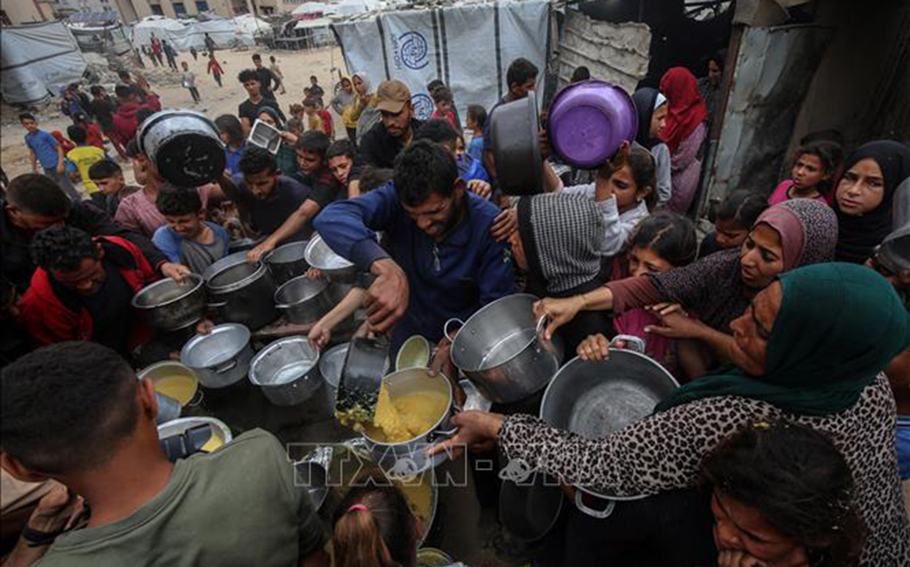 Người dân Palestine nhận thực phẩm cứu trợ tại Gaza.