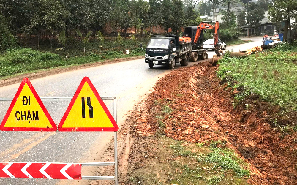 Công nhân Công ty cổ phần Xây dựng đường bộ 1 Yên Bái khơi thông cống rãnh, bảo đảm giao thông mùa mưa bão.