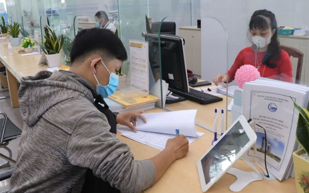 Cán bộ tỉnh Bình Dương hỗ trợ người dân giải quyết thủ tục hành chính.