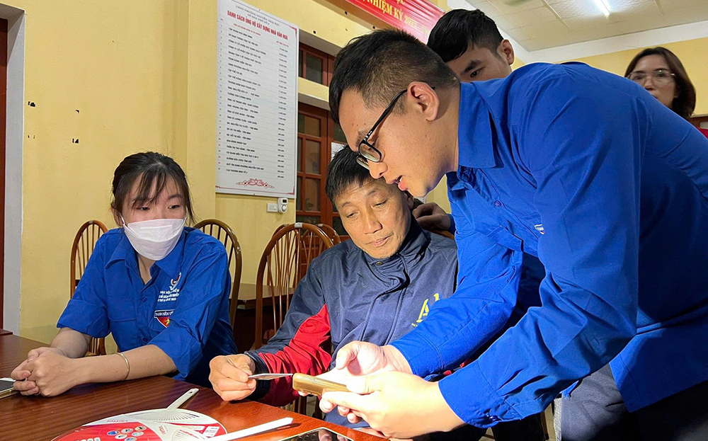 Đoàn viên thanh niên hướng dẫn người dân cài đặt và sử dụng mạng xã hội để lan tỏa những thông tin tích cực.