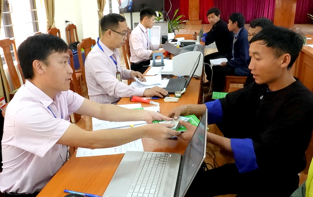 Cán bộ Chi nhánh Ngân hàng chính sách huyện Mù Cang Chải giải ngân vốn vay cho các hộ nghèo, hộ cận nghèo.