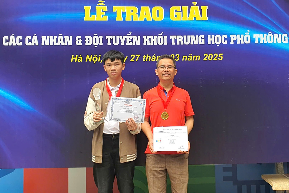 Đặng Huy Hậu cùng thầy Nguyễn Ngọc Tuấn, Tổ trưởng Tổ Tin học và cũng là giáo viên trực tiếp dạy trên lớp, bồi dưỡng Hậu tại Trường THPT Chuyên Thăng Long - Đà Lạt. Ảnh chụp tại lễ trao giải một cuộc thi về Tin học năm 2025.