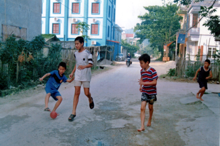 Thiếu sân chơi, trẻ em đá bóng ngay trên đường phố gây mất ATGT.
