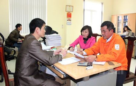 Cán bộ Chi cục Thuế huyện Yên Bình hướng dẫn người nộp thuế. (Ảnh: Quang Thiều)