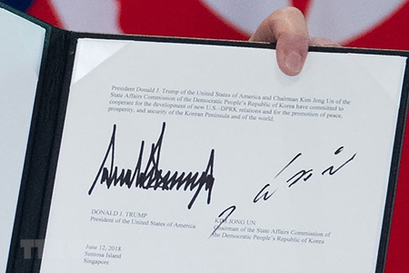 Văn kiện chung lưu lại chữ ký của Tổng thống Mỹ Donald Trump (trái) và của nhà lãnh đạo Triều Tiên Kim Jong-un (phải) tại Sentosa, Singapore ngày 12/6.
