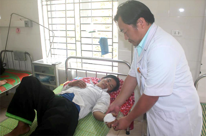 Cán bộ Trung tâm Y tế huyện Trạm Tấu kiểm tra vết thương của người bị TNLĐ.