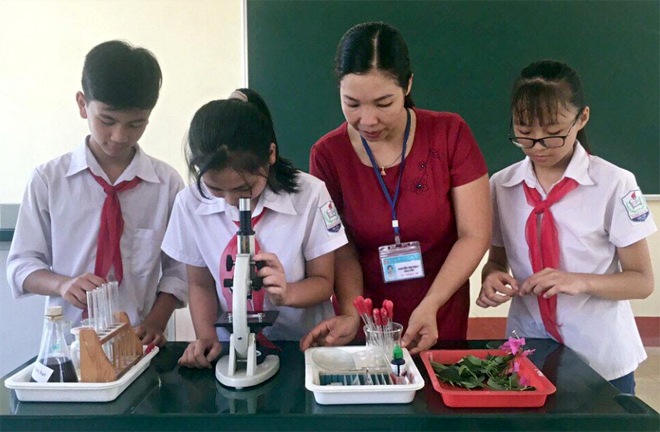 Cô giáo Nguyễn Thị Nhẫn hướng dẫn học sinh làm thí nghiệm.